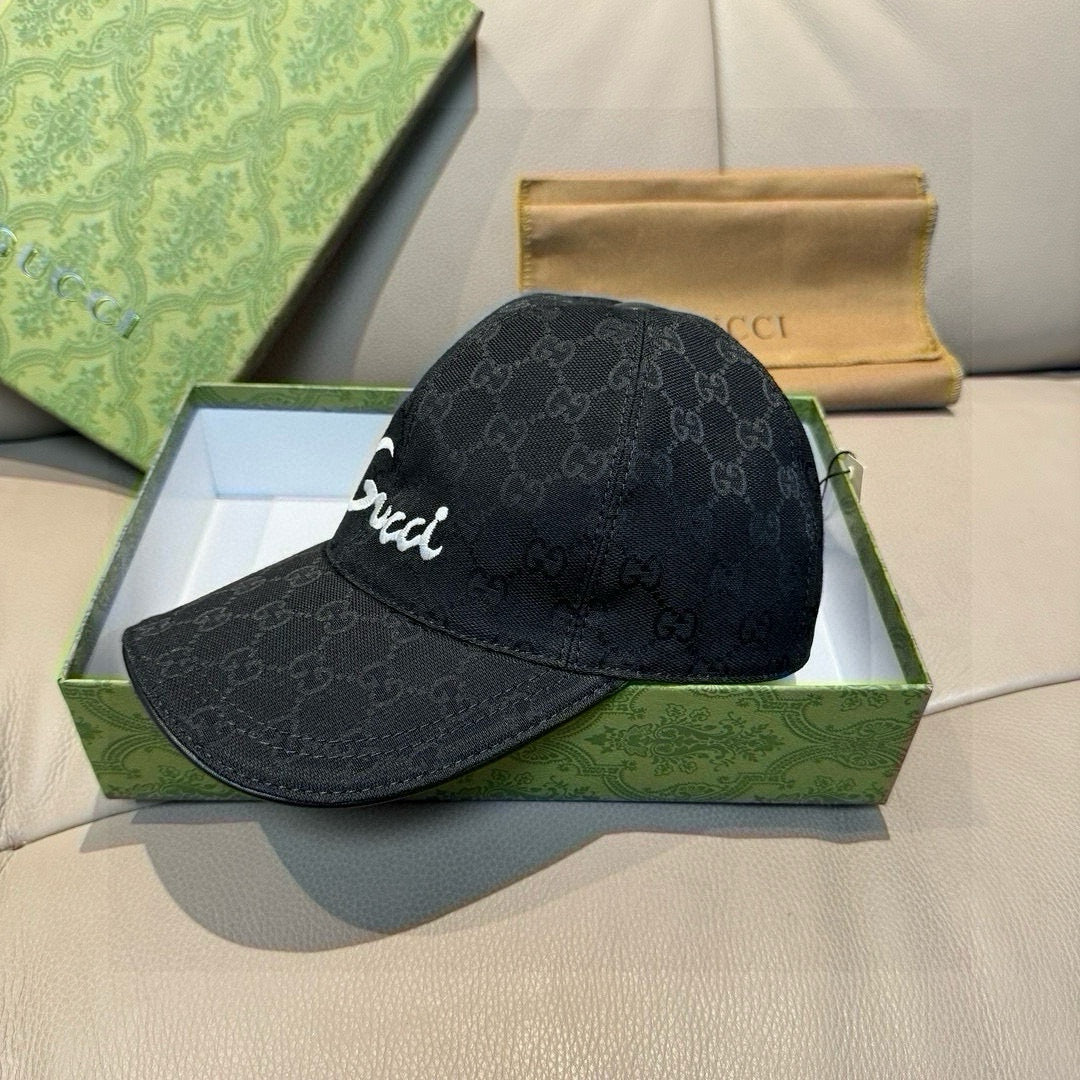 Black GG monogram baseball cap with white 'Gucci' script on front brim.