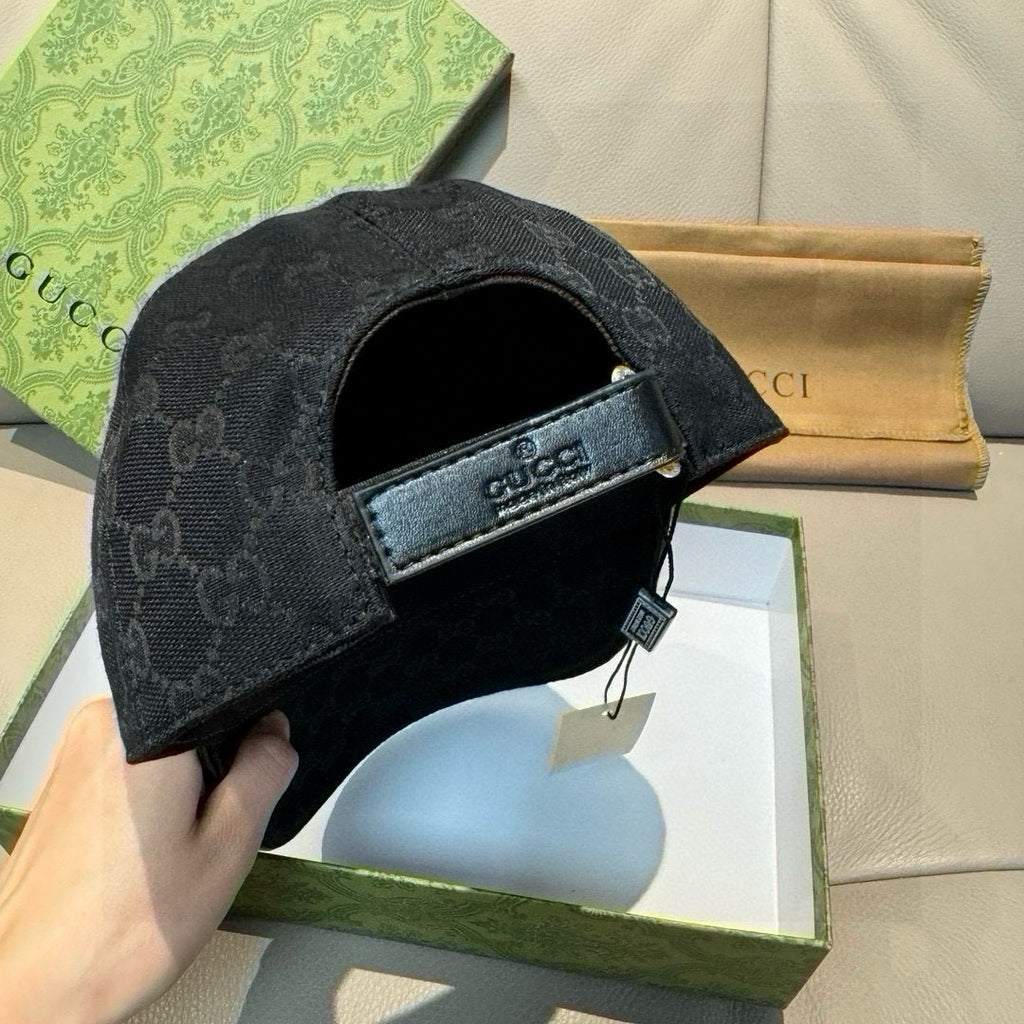Black GG monogram cap with adjustable strap and Gucci-branded back patch.