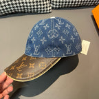 Blue monogram baseball cap top view with brown brim; hand holding at edge