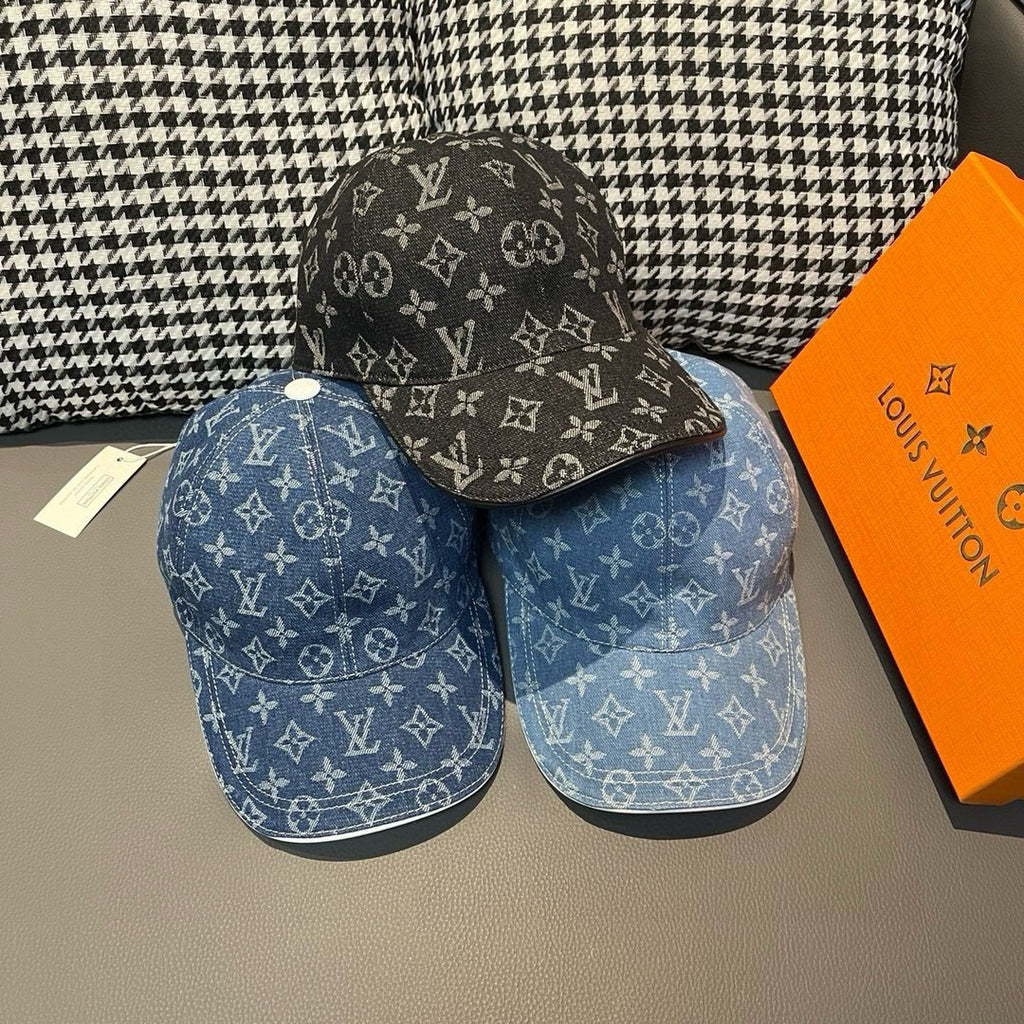 Pair of Louis Vuitton monogram denim caps: blue and black, each with curved brim.