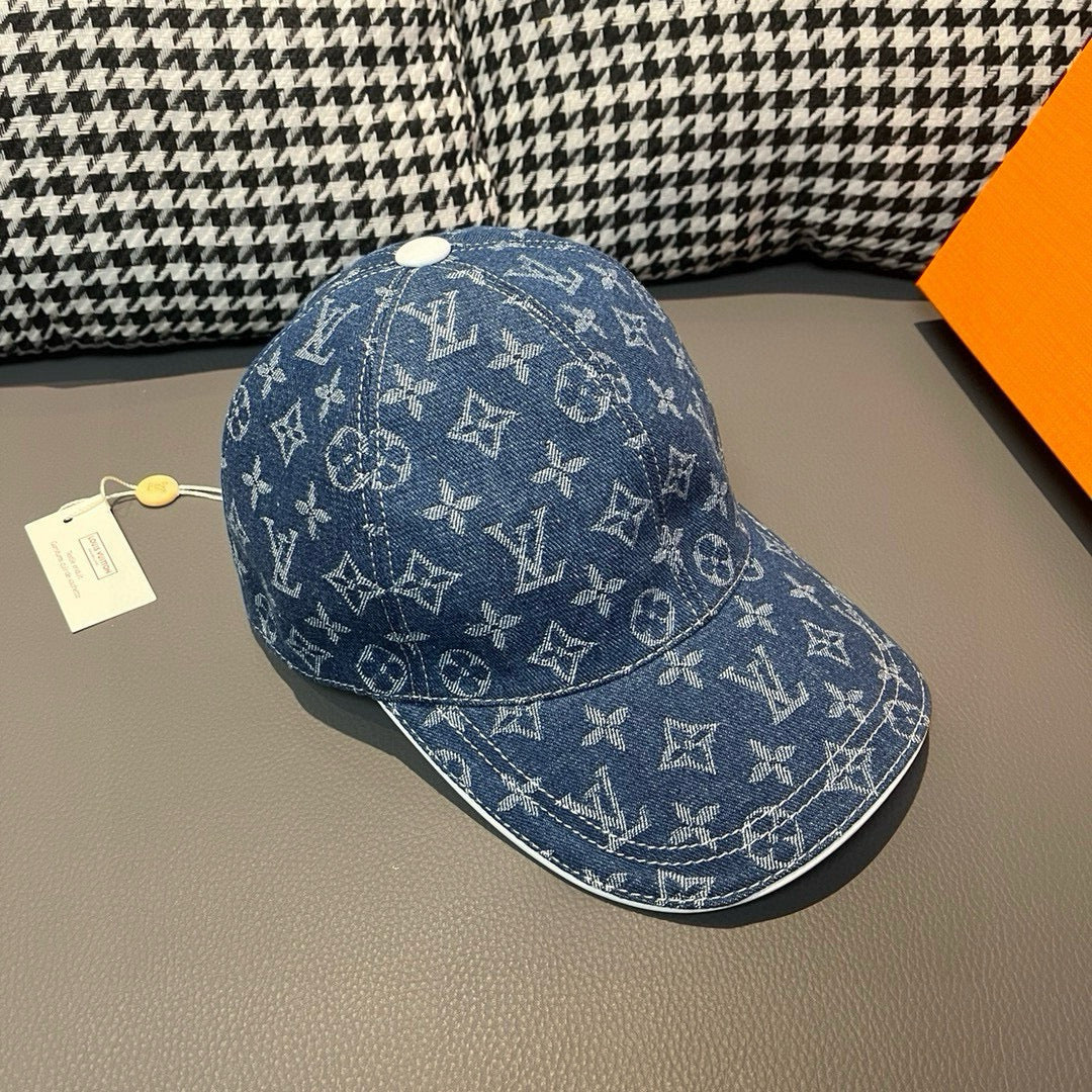 Louis Vuitton denim monogram cap in blue with white emblem pattern, side profile.