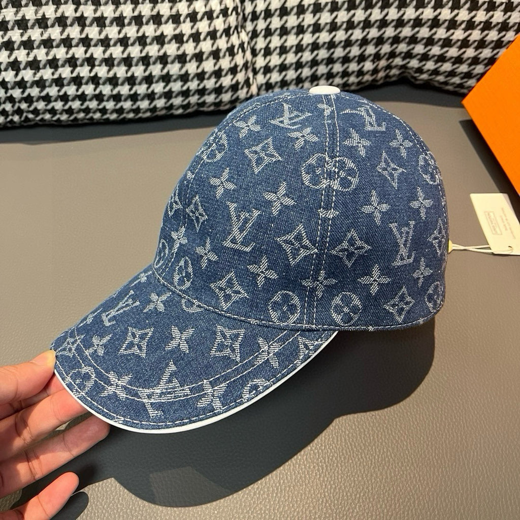 Louis Vuitton denim monogram cap in blue with white pattern, held by hand side view.