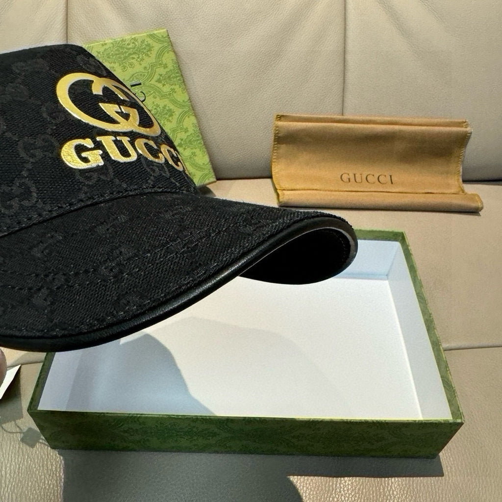Black Gucci baseball cap with GG monogram and gold Gucci logo at front edge.