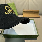 Black Gucci baseball cap with GG monogram and gold Gucci logo at front edge.