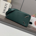Teal leather bag with top bar hardware and adjustable shoulder strap.