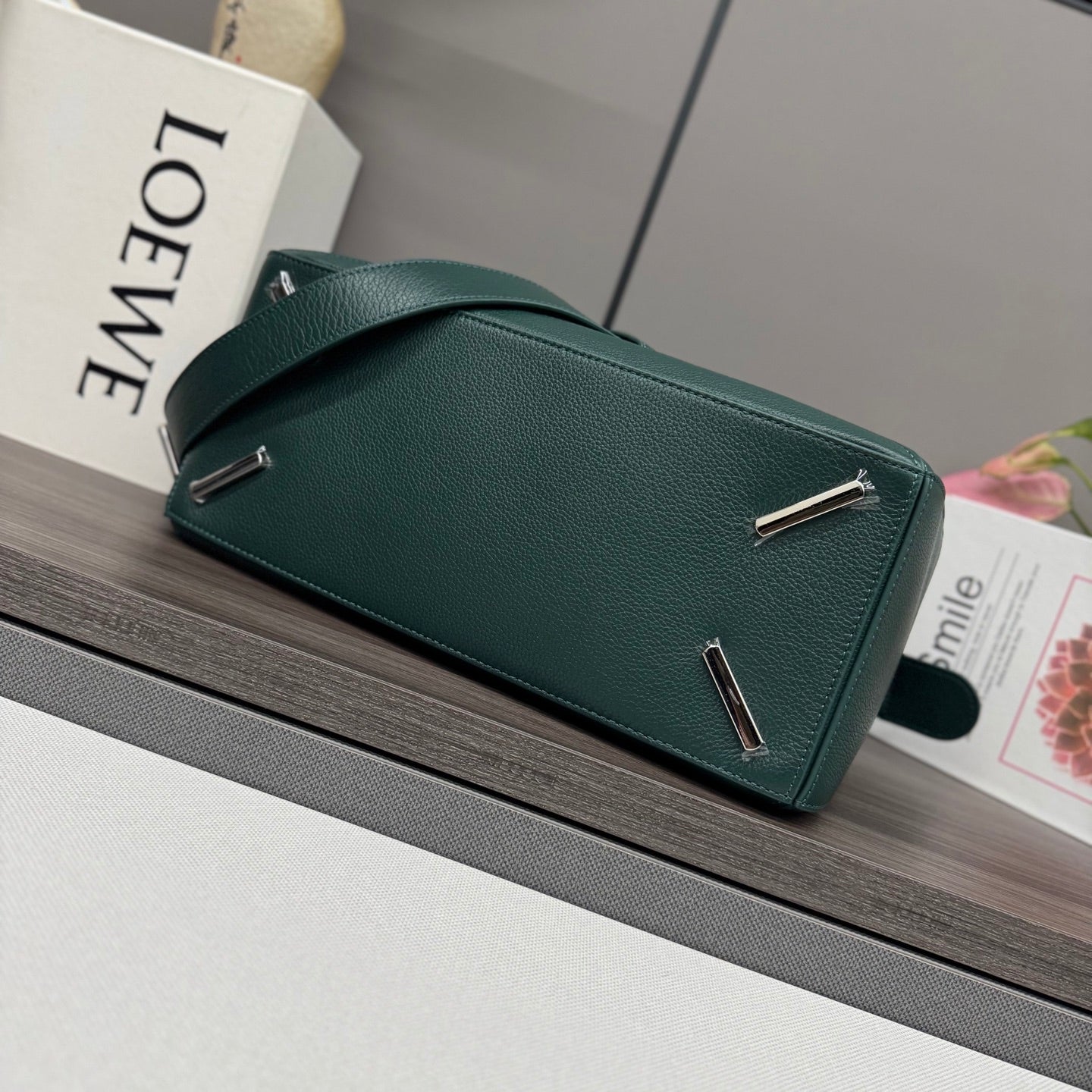 Teal leather bag with top bar hardware and adjustable shoulder strap.