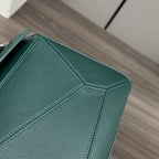 Teal leather bag side with geometric stitched panel lines and textured finish.
