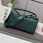 Teal leather shoulder bag with top handle, structured panels, and metal clasp.