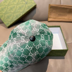Green GG monogram baseball cap close-up with dark round top button.