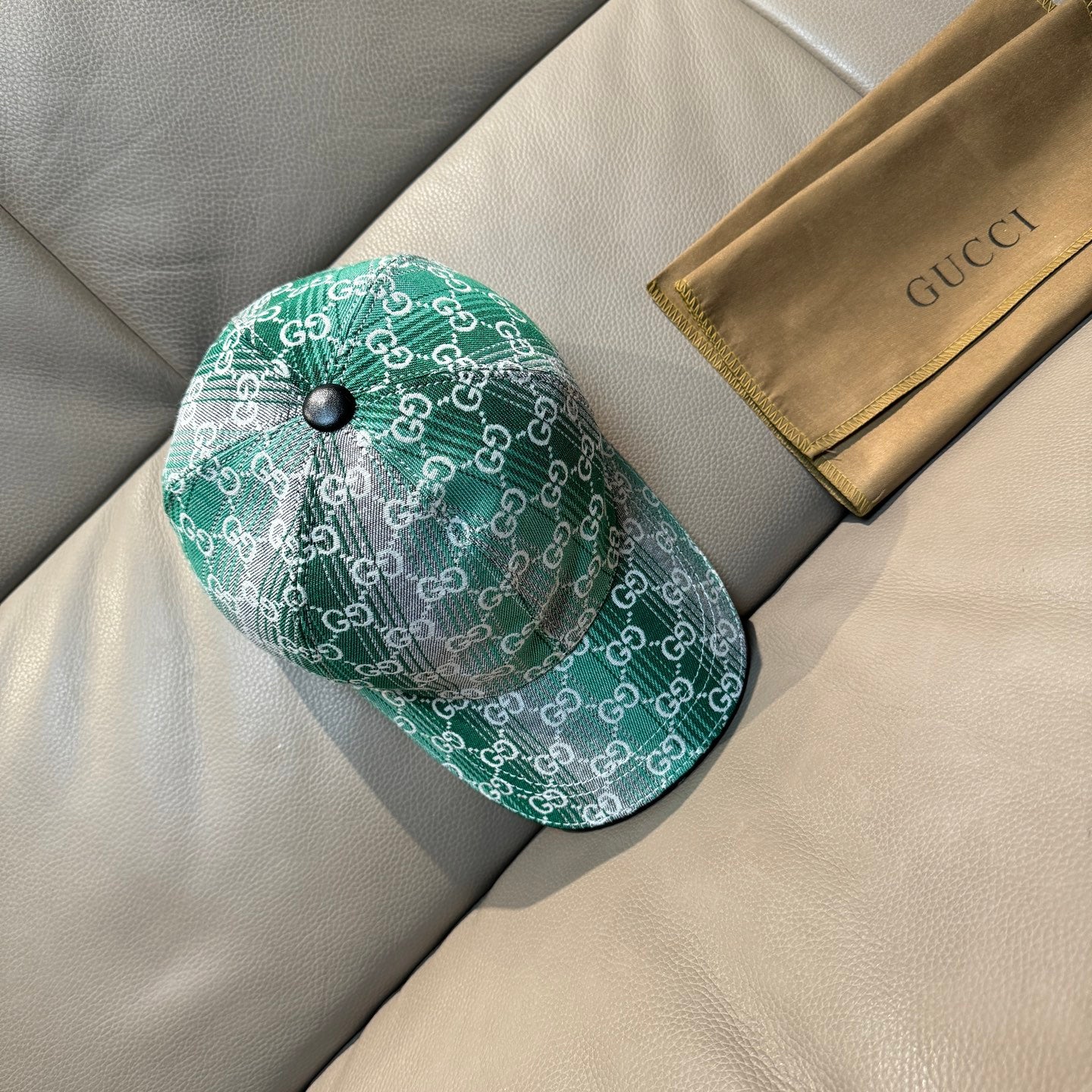 Green GG monogram baseball cap with metal button, curved brim, and side view.