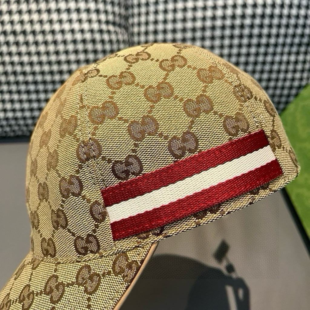 Tan GG cap close-up with red-and-white stripe across the side