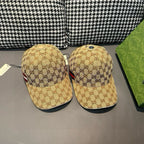 Two tan GG baseball caps with red-and-white stripes side by side