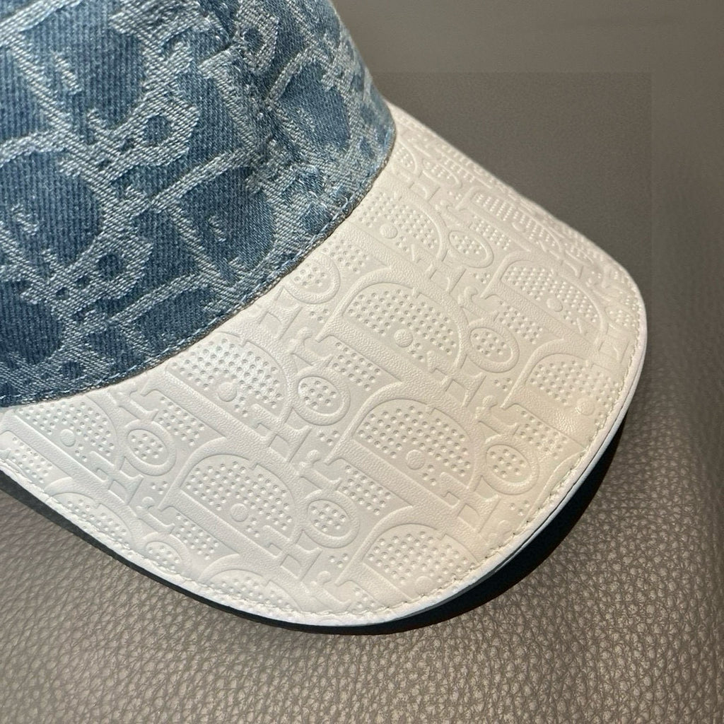 Dior cap brim close-up: white textured base with embossed logo pattern and edge stitch
