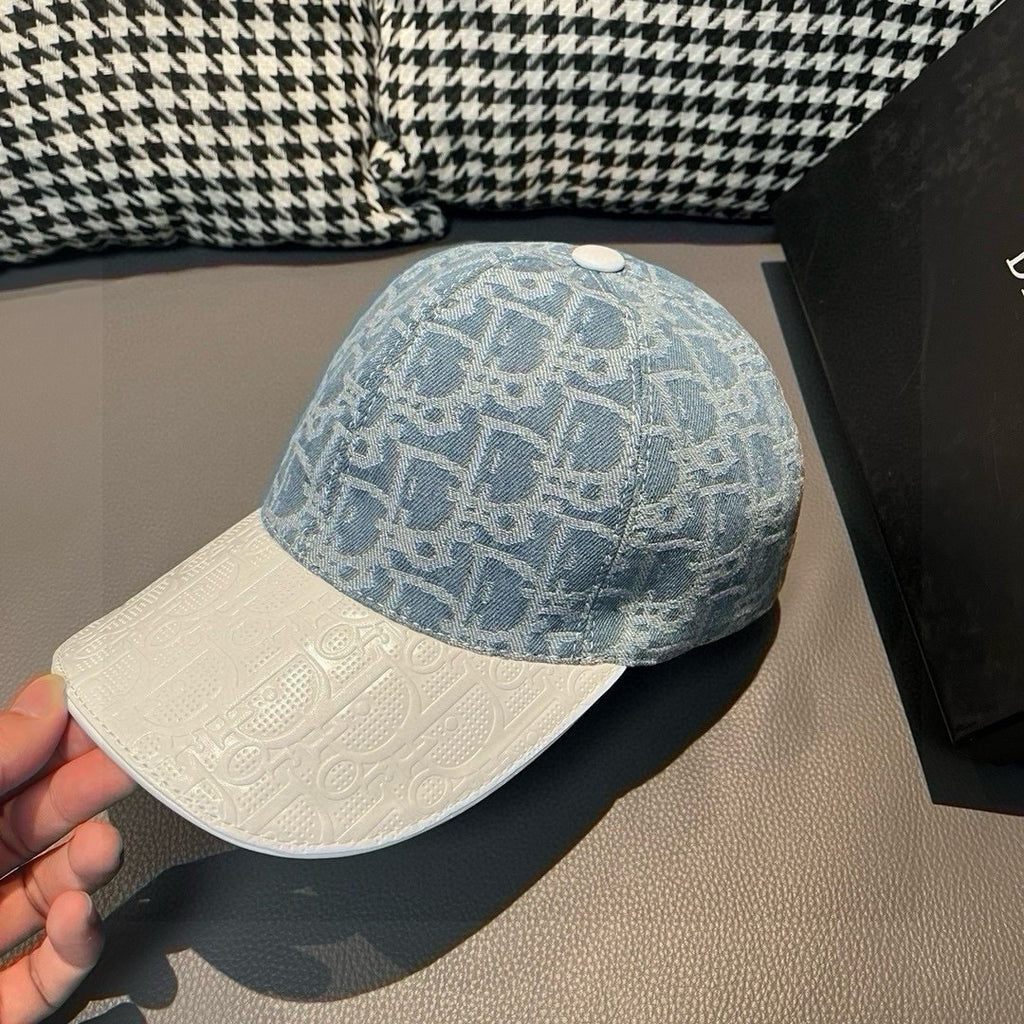 Dior cap held by hand: blue logo crown with white textured brim and curved visor
