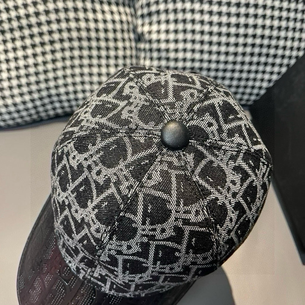 Dior cap top close-up with black and gray monogram fabric and button.
