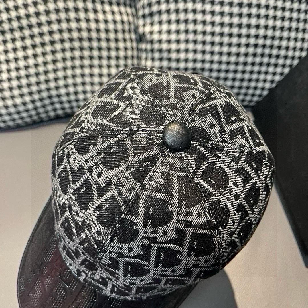 Dior cap top close-up with black and gray monogram fabric and button.
