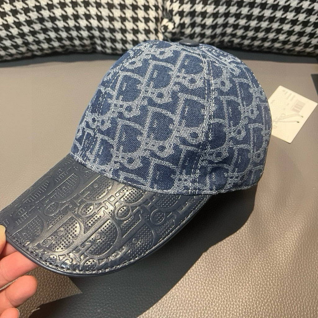 Blue monogram baseball cap with curved brim; top button and front panel visible.