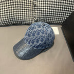 Blue monogram-pattern baseball cap with curved brim and small top button; angled view.