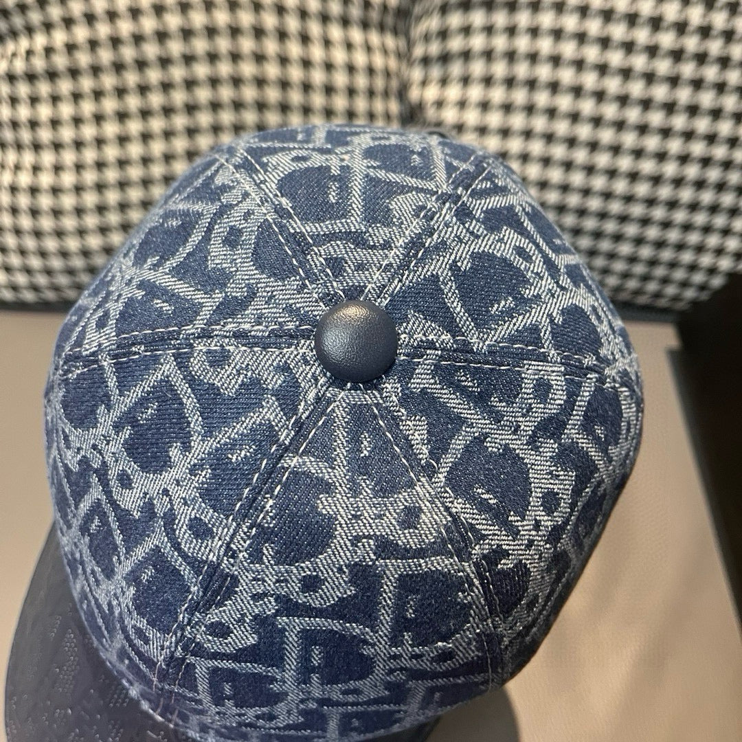 Close-up of blue cap crown with white monogram pattern and round metal top button.