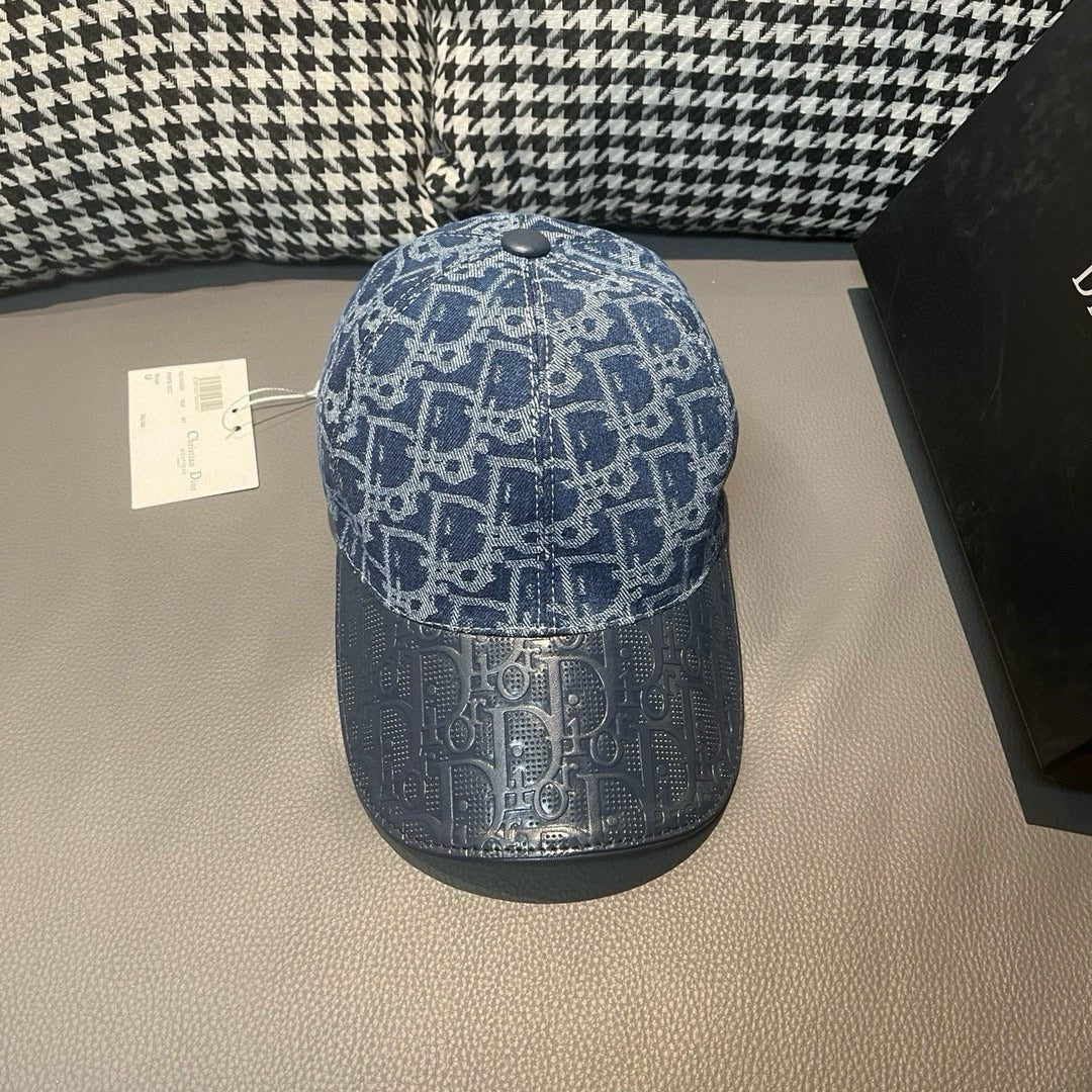 Blue baseball cap with white monogram-style pattern and curved brim; adjustable button top.