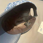 Inside view of blue baseball cap showing dark interior lining and adjustable strap.