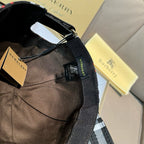 Plaid cap interior view with adjustable strap and black webbing; metal ring at side