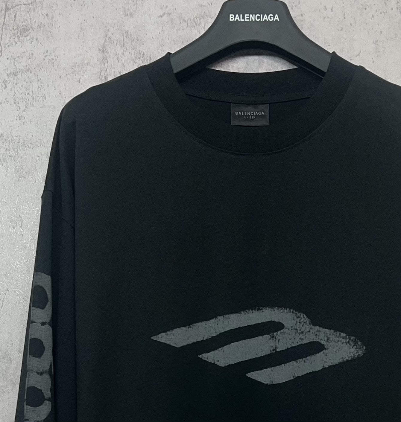 Balenciaga long-sleeve T-shirt, dark upper front close-up with “B” style logo
