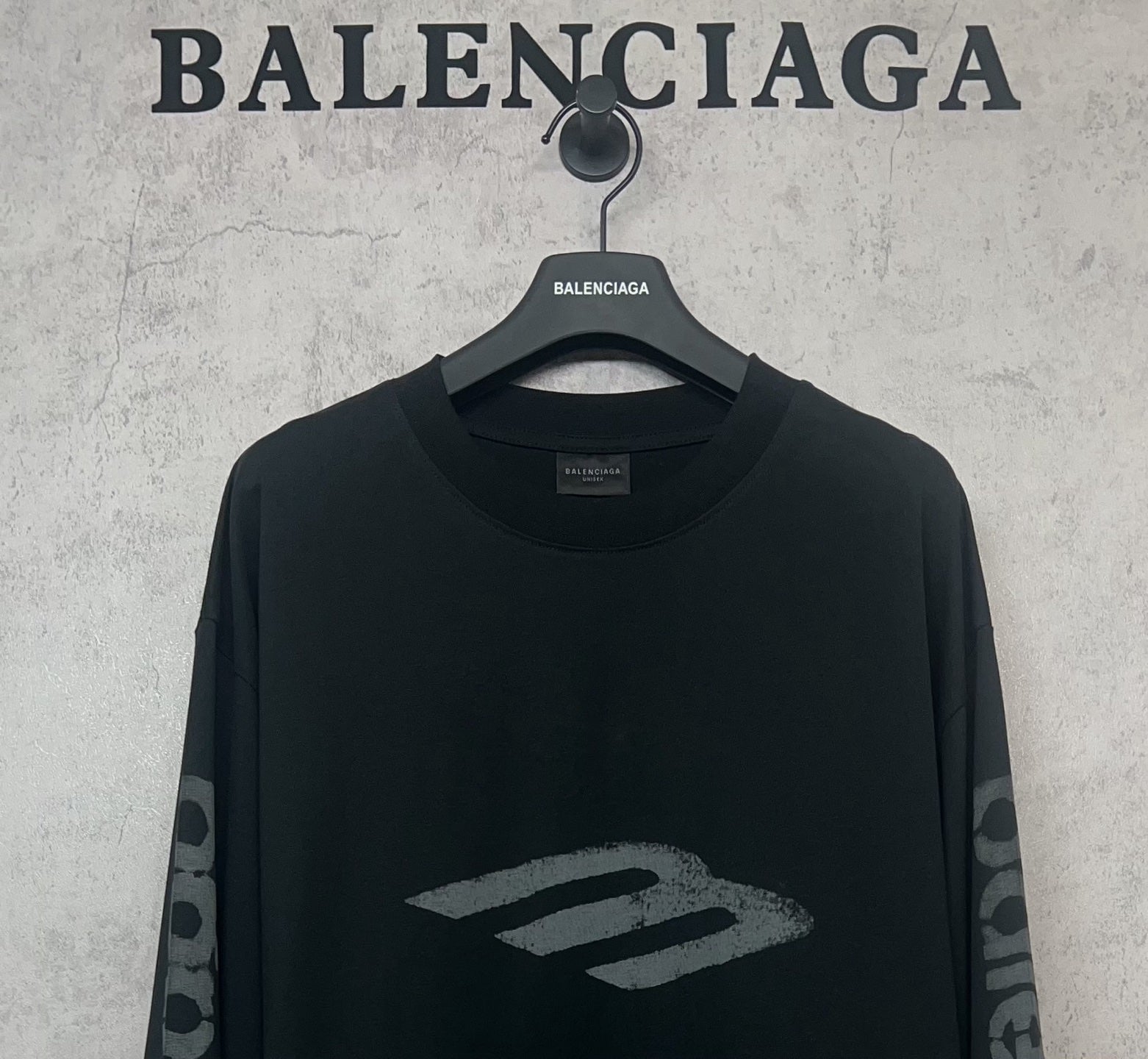 Balenciaga long-sleeve T-shirt, dark front close-up with large “B” style logo