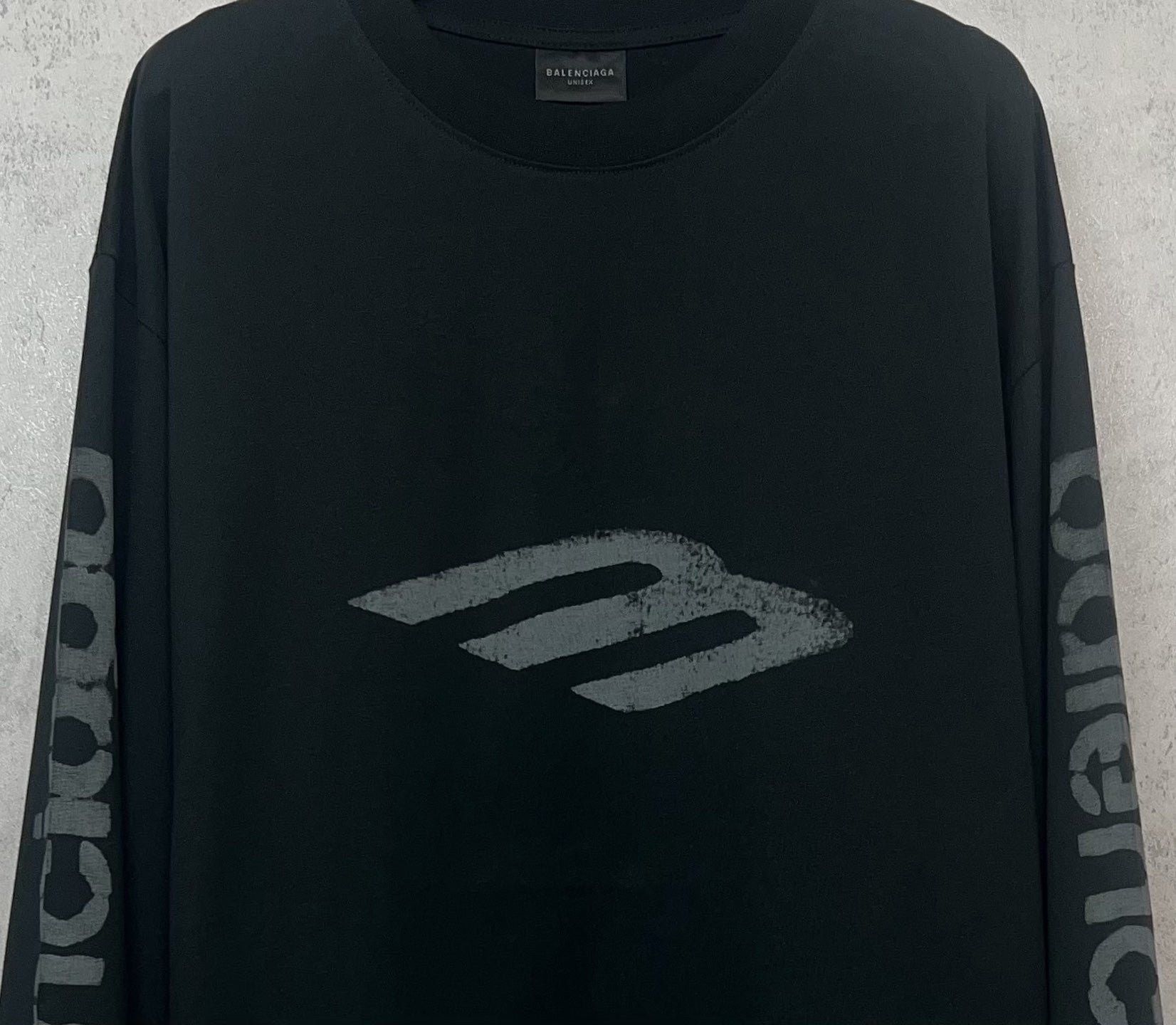Balenciaga long-sleeve T-shirt, dark front close-up with large “B” style logo graphic