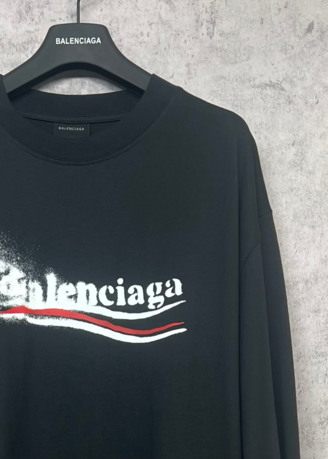 Black long-sleeve shirt with Balenciaga logo on front, side view