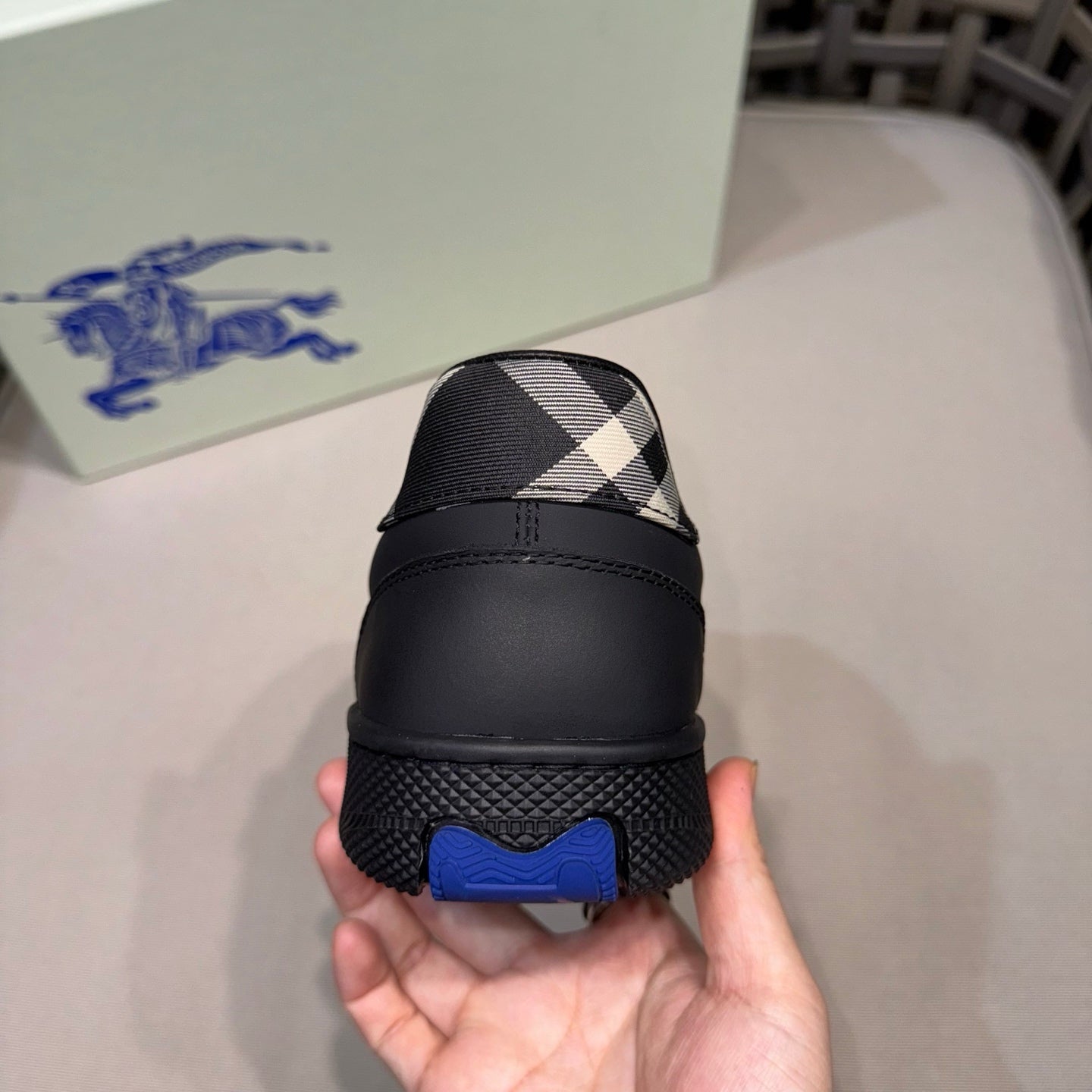 Burberry black sneakers heel with plaid insert and blue logo tab, back view