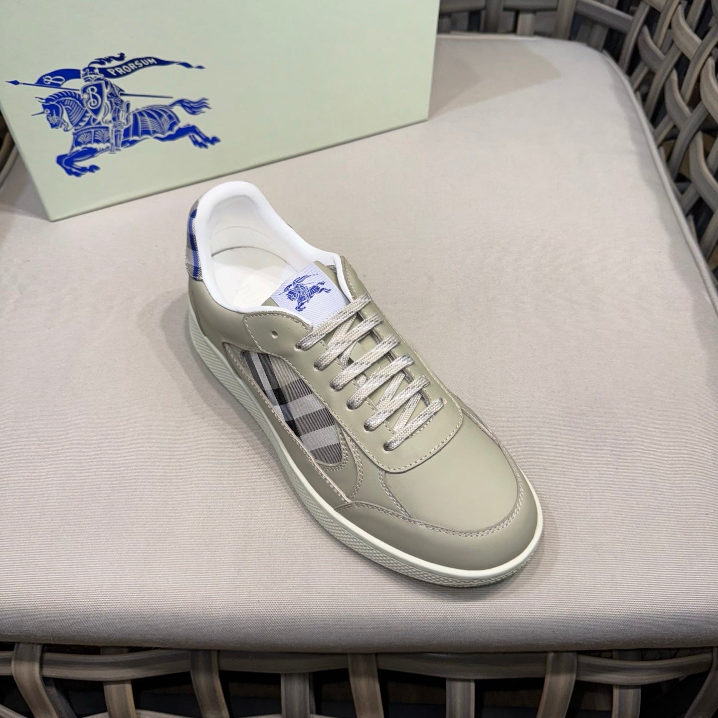 Burberry low-top sneaker single view with beige leather, blue laces, and check overlay