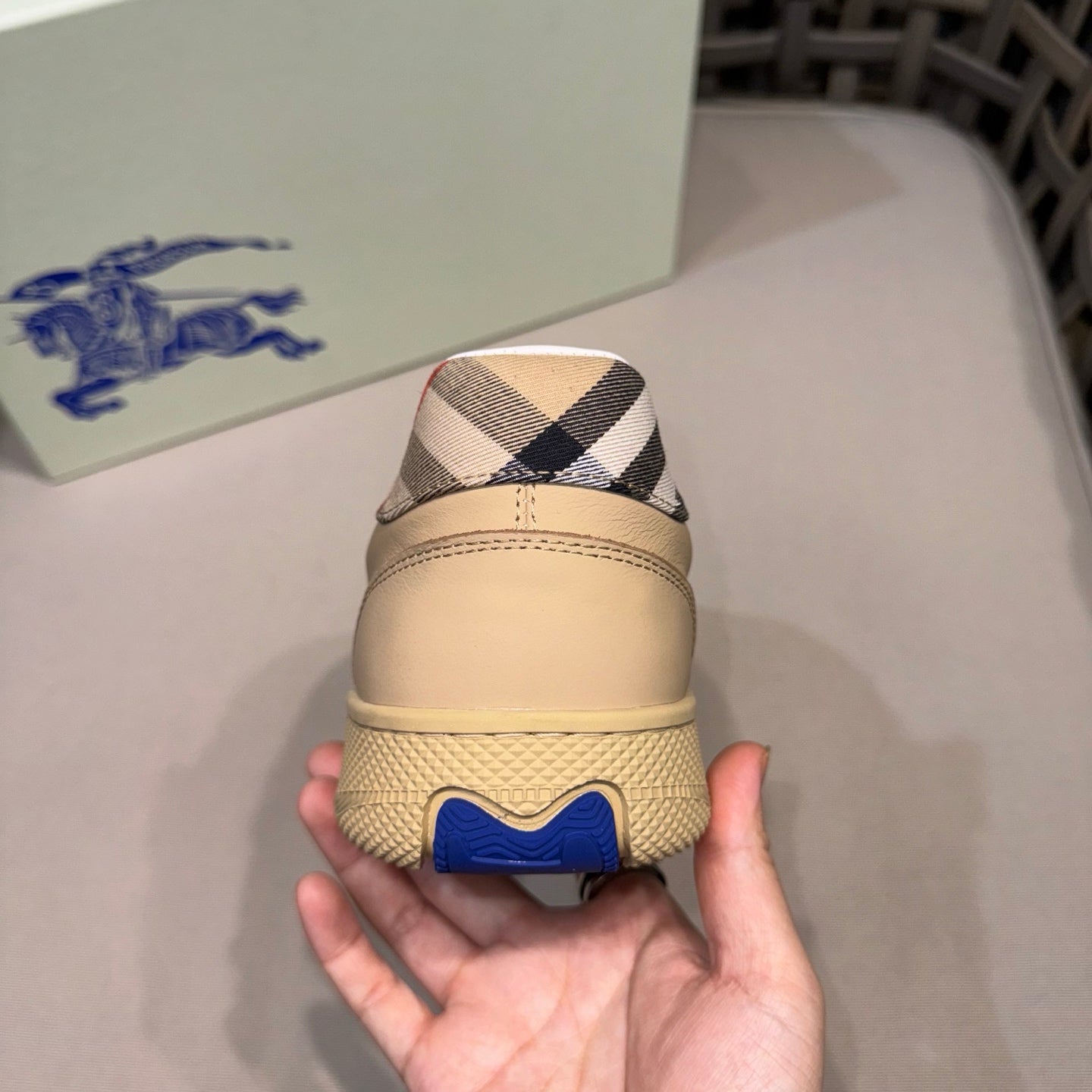 Beige sneaker heel with black-and-white check trim and blue heel logo
