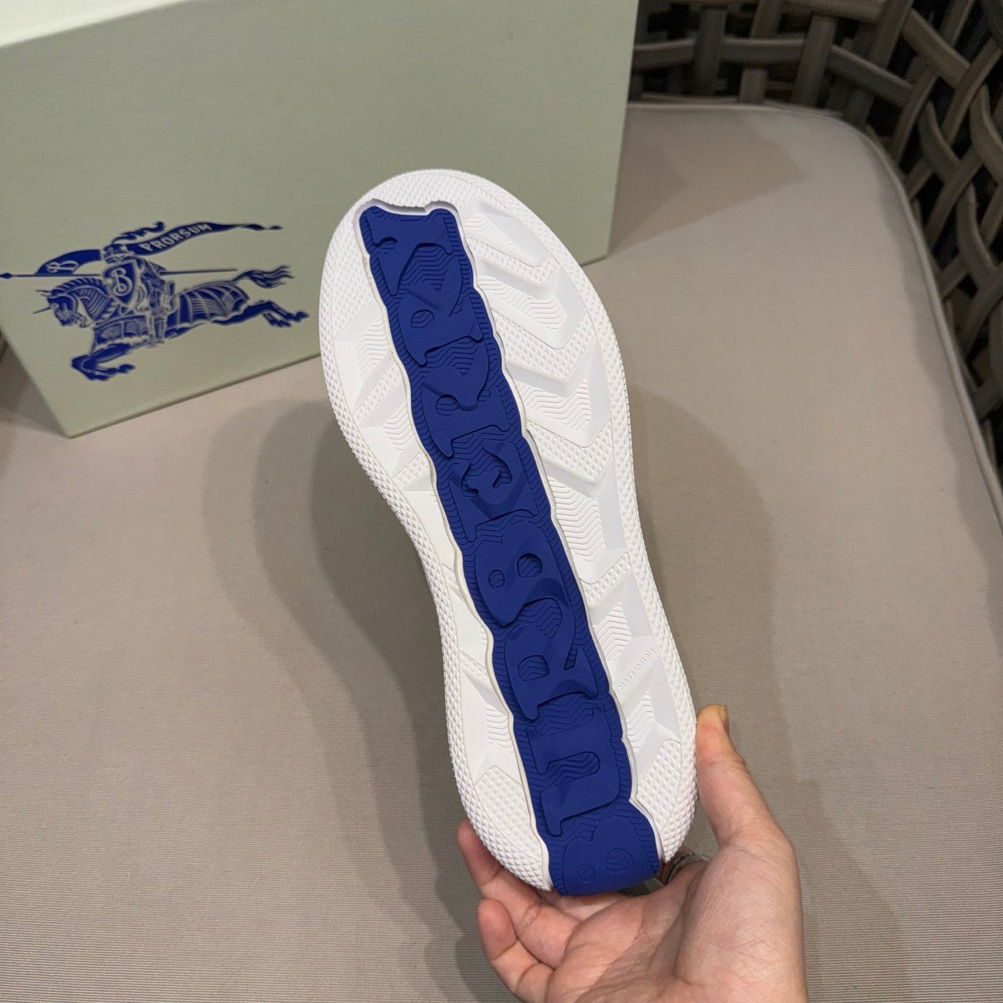 Blue traction outsole on white leather sneaker with textured tread