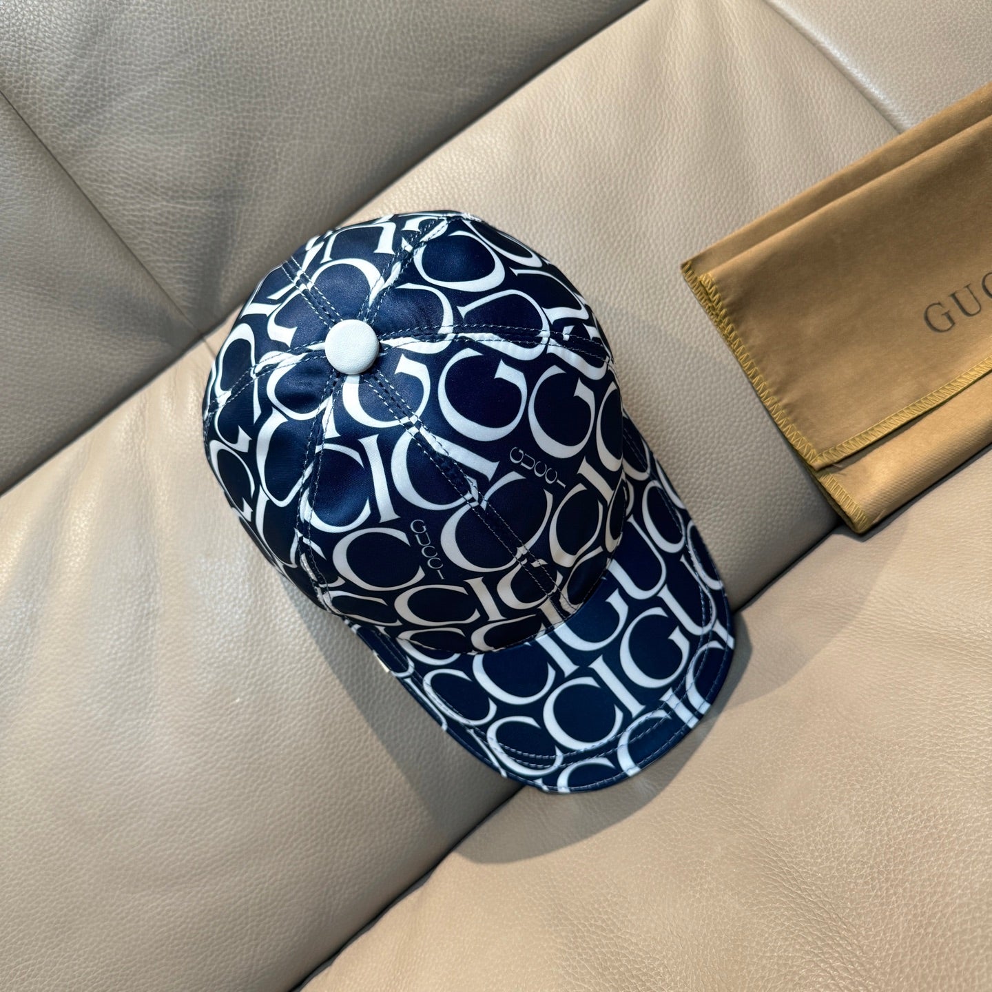 Gucci baseball cap side view in navy and white GG monogram with white button top