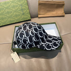 Gucci cap with black-and-white GG pattern, curved brim, and matching fabric strap