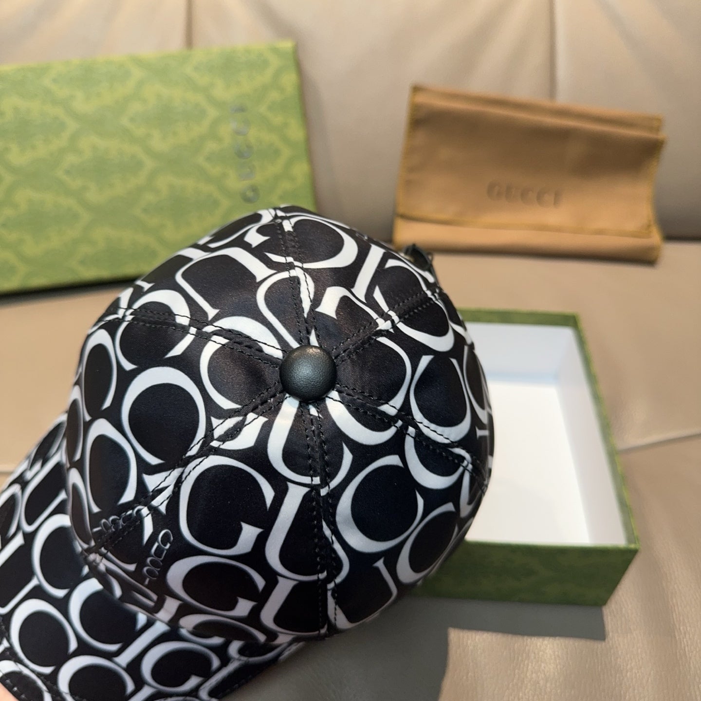 Gucci cap top close-up with black button and black-and-white GG pattern