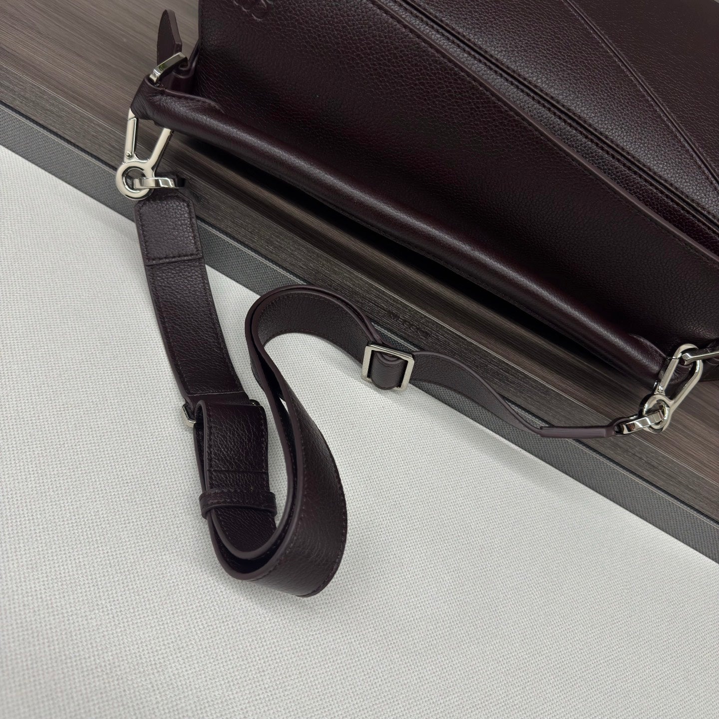 Loewe dark brown leather bag with adjustable crossbody strap and silver buckle
