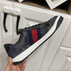 Gucci unisex denim sneaker on hand, dark blue with red-and-blue stripe panel, white sole