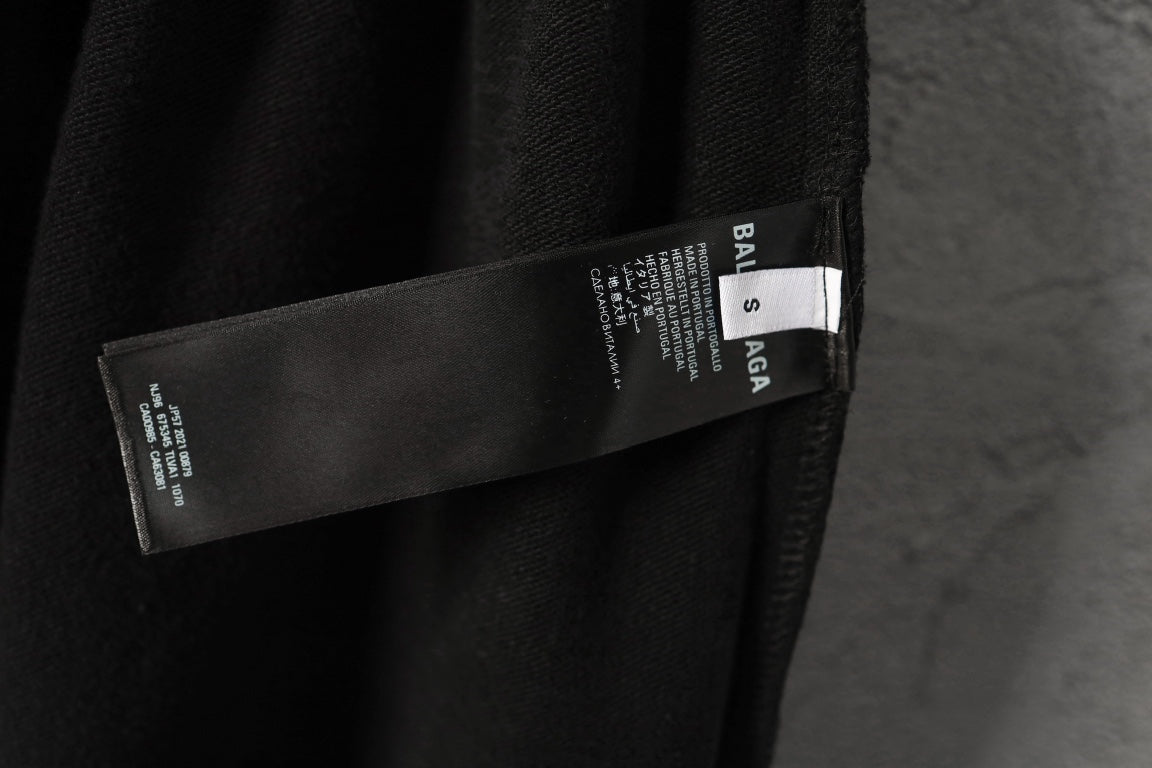 Black pants with Balenciaga label and care tag near side seam