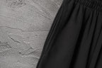 Black gathered waistband with pleated fabric panels