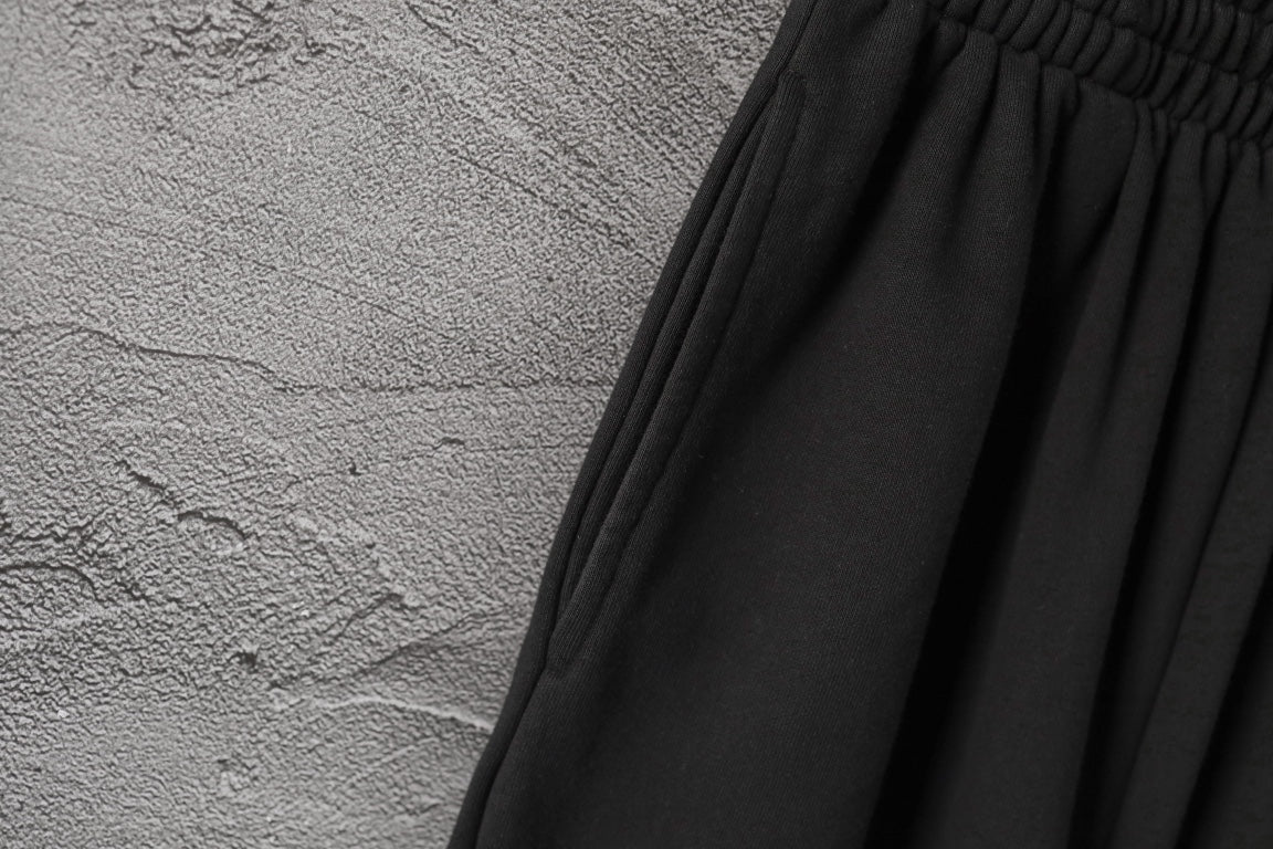 Black gathered waistband with pleated fabric panels