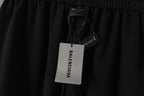 Black pants with hanging retail tags and small logo on waistband