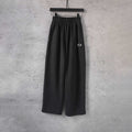 Black wide-leg pants with elastic waistband and front logo patch