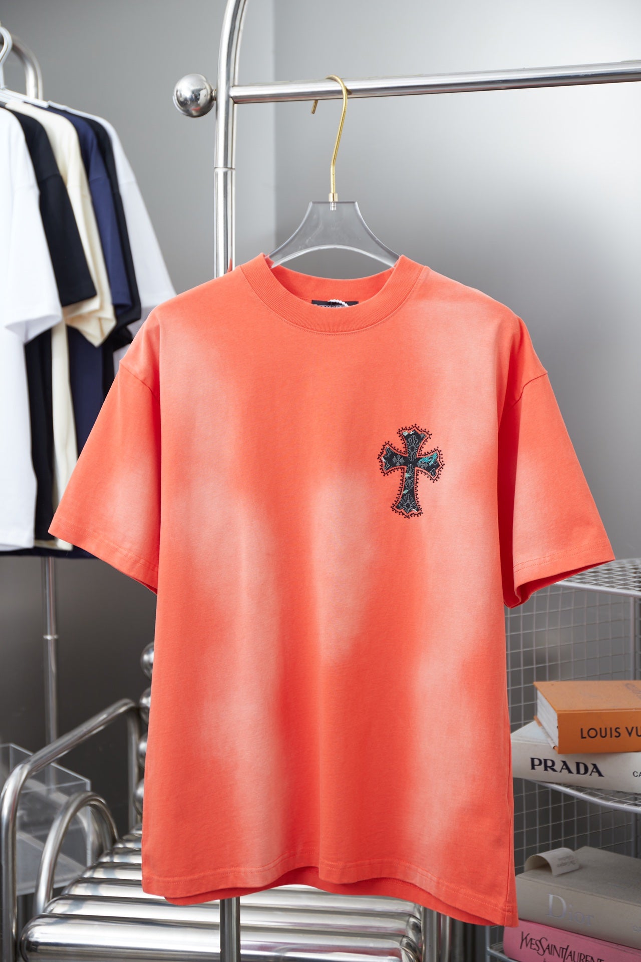 Coral short-sleeve T-shirt with navy cross logo on chest