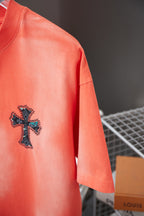 Coral short-sleeve T-shirt with small cross graphic on front