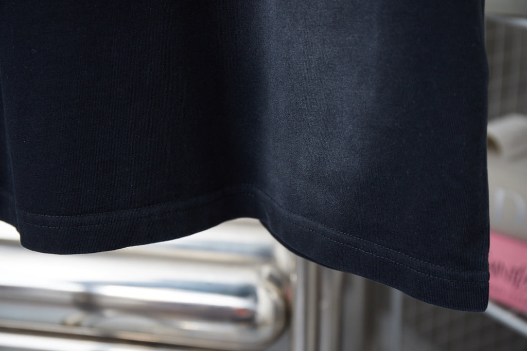 Dark short-sleeve T-shirt hem seam detail.