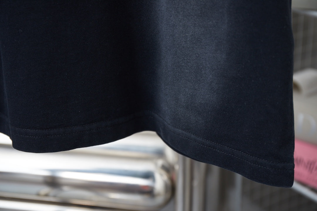 Dark short-sleeve T-shirt hem seam detail.