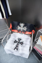 Folded T-shirts on a cart: white and dark with cross graphic prints