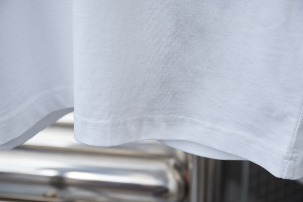 White short-sleeve T-shirt hem with visible stitching